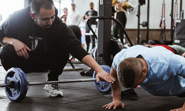 Personal trainer guiding a client through push-up exercises during a one-on-one strength training session at Freedom Fitness O’Fallon.
